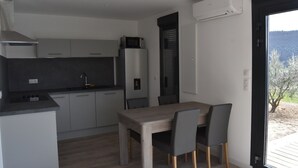 Eine moderne Küche mit grauen Schränken, einer eingebauten Mikrowelle und einem Essbereich mit Holztisch und Stühlen.