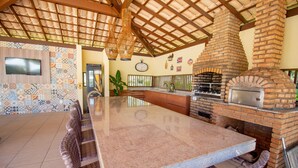 Una cocina amplia con una isla grande, horno de ladrillo y salpicadero de azulejos.