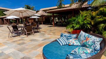 Una piscina al aire libre, sombrillas, sillones reclinables de piscina