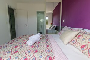 A bedroom with a bed, a bathroom, and a closet. - GB11 Otimo Ap Genipabu Sum Residence (Camaçari)