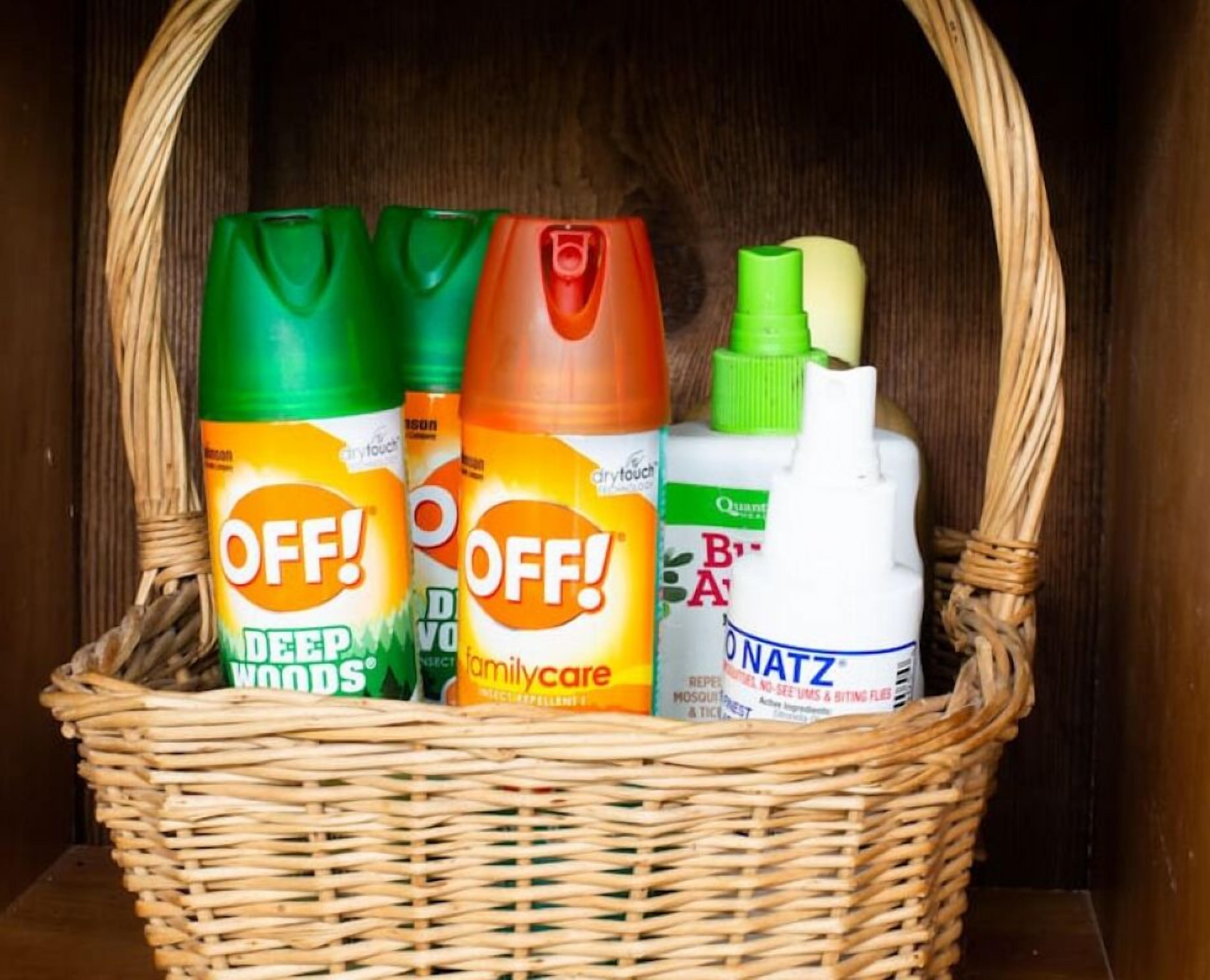 Uma cesta de vime com quatro embalagens de produtos de limpeza doméstica.