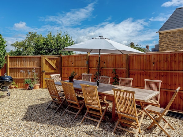 A wooden deck with a table and chairs, surrounded by a wooden fence.