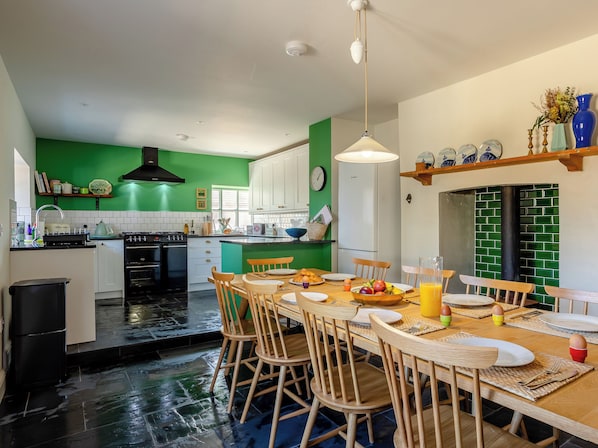 A kitchen with a dining area, a stove, oven, and a refrigerator.