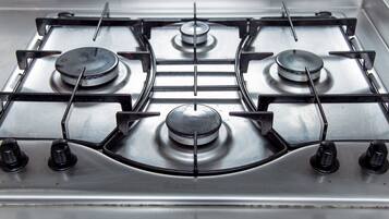 Una estufa a gas con cuatro quemadores y una perilla de control.