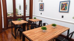 A dining area with wooden tables and chairs, potted plants, and artwork on the walls. - Avenida Tango (Buenos Aires)