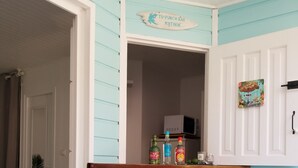 A kitchen with a sign reading "Ti-Punch Bar Matinik," a microwave, and a shelf with bottles. - Studios Paradis Turquoise, swimming pool, beach, Les Trois ilets (les 3 ilets)