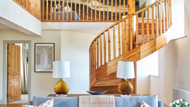 A spacious living area with a wooden staircase, a sofa set, and two lamps. - 2 bedroom accommodation in Glencraigs, near Campbeltown (Glencraigs, near Campbeltown)