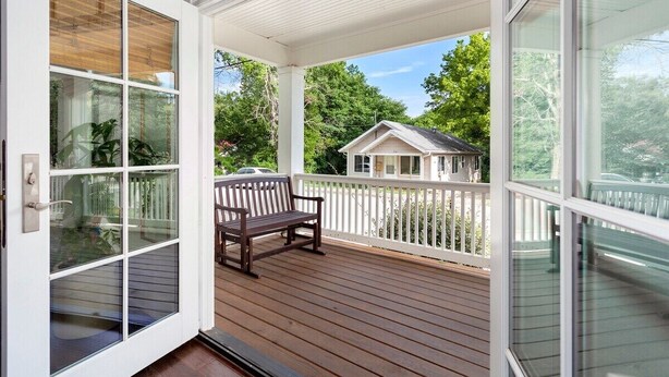 A wooden deck with a bench, white railings, and a view of a house across the deck. - The SoFay Farmhouse - 1 mi From U of A (Fayetteville)