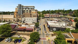 A downtown area with a mix of commercial buildings, including a prominent multi-story structure with a modern design. - The East View - Downtown - Steps to Dickson (Fayetteville)