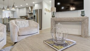 A modern living room with a round coffee table, a sofa, and a fireplace. - Crown - A Birdy Vacation Rental (San Antonio)