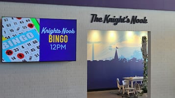 Eine Wand mit einem BINGO-Schild und einem Schild für das Restaurant 'The Knight's Nook'.