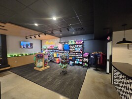 Una tienda minorista con una gran variedad de productos, incluyendo ropa y accesorios, organizados en estantes y perchas.