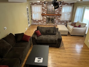Relax in this inviting living room with a brick fireplace, two sofas, and a coffee table for comfortable seating and entertainment.