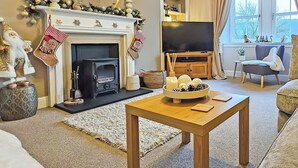 A cozy living room with a fireplace, a television, and a comfortable seating area.