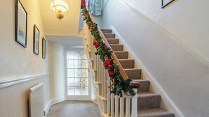 A carpeted staircase with a white handrail and a garland of red and green decorations. - 3 bedroom accommodation in Thornholme, near Driffield (Thornholme, near Driffield)