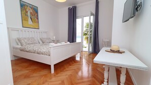 Ein Schlafzimmer mit einem Bett, einem Tisch und einem Bild an der Wand.
