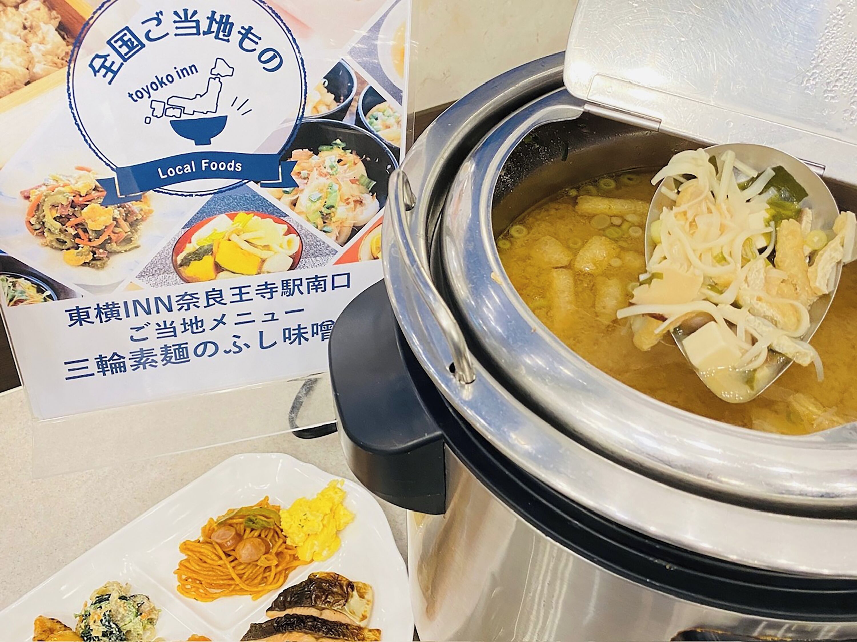 A traditional Japanese hot pot setup with a variety of ingredients visible, including tofu and vegetables.