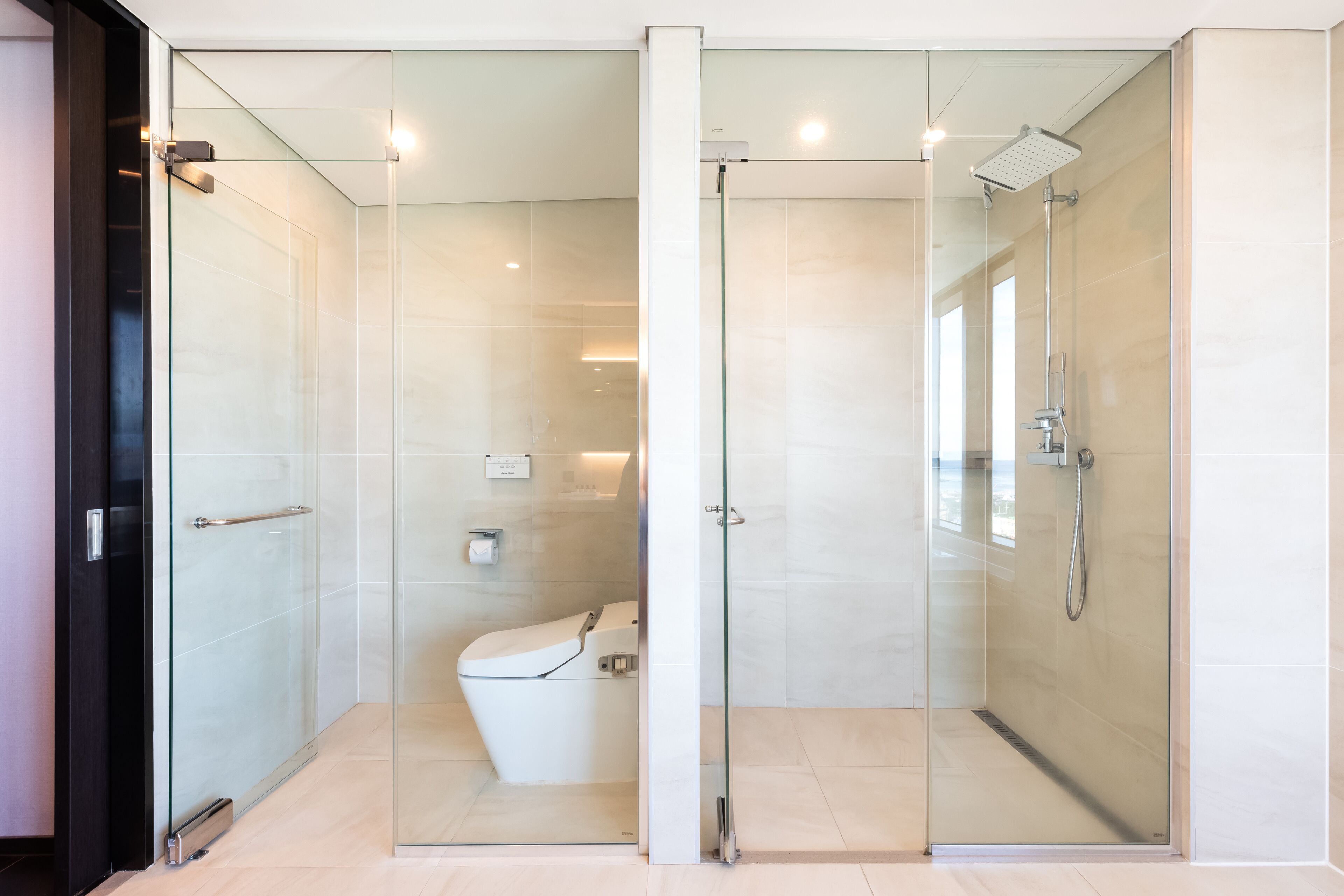 Un bagno moderno con doccia vetrata, un water e una porta in vetro.