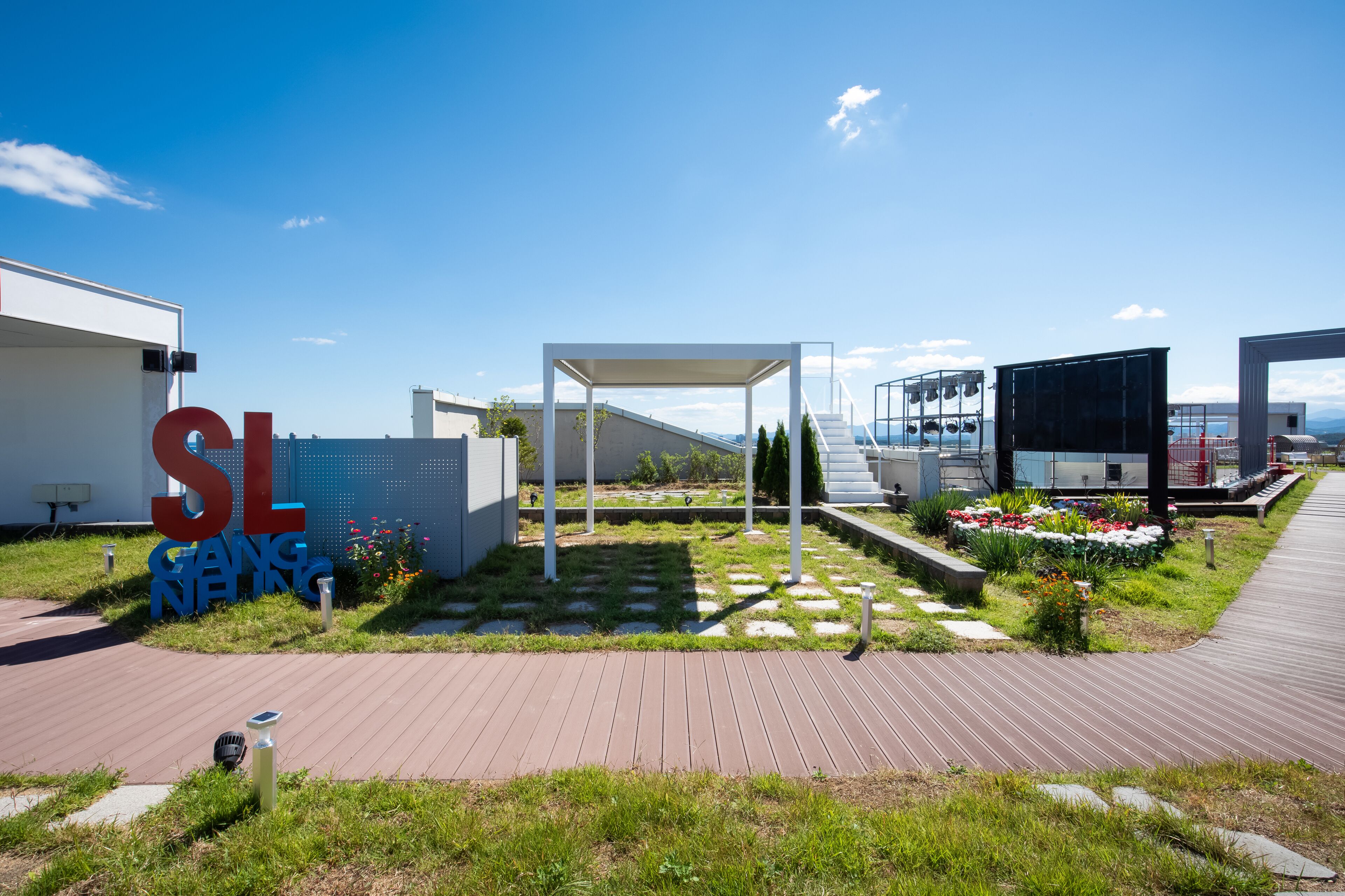 A modern outdoor area with a pergola, a pathway, and a sign reading "SL RING".