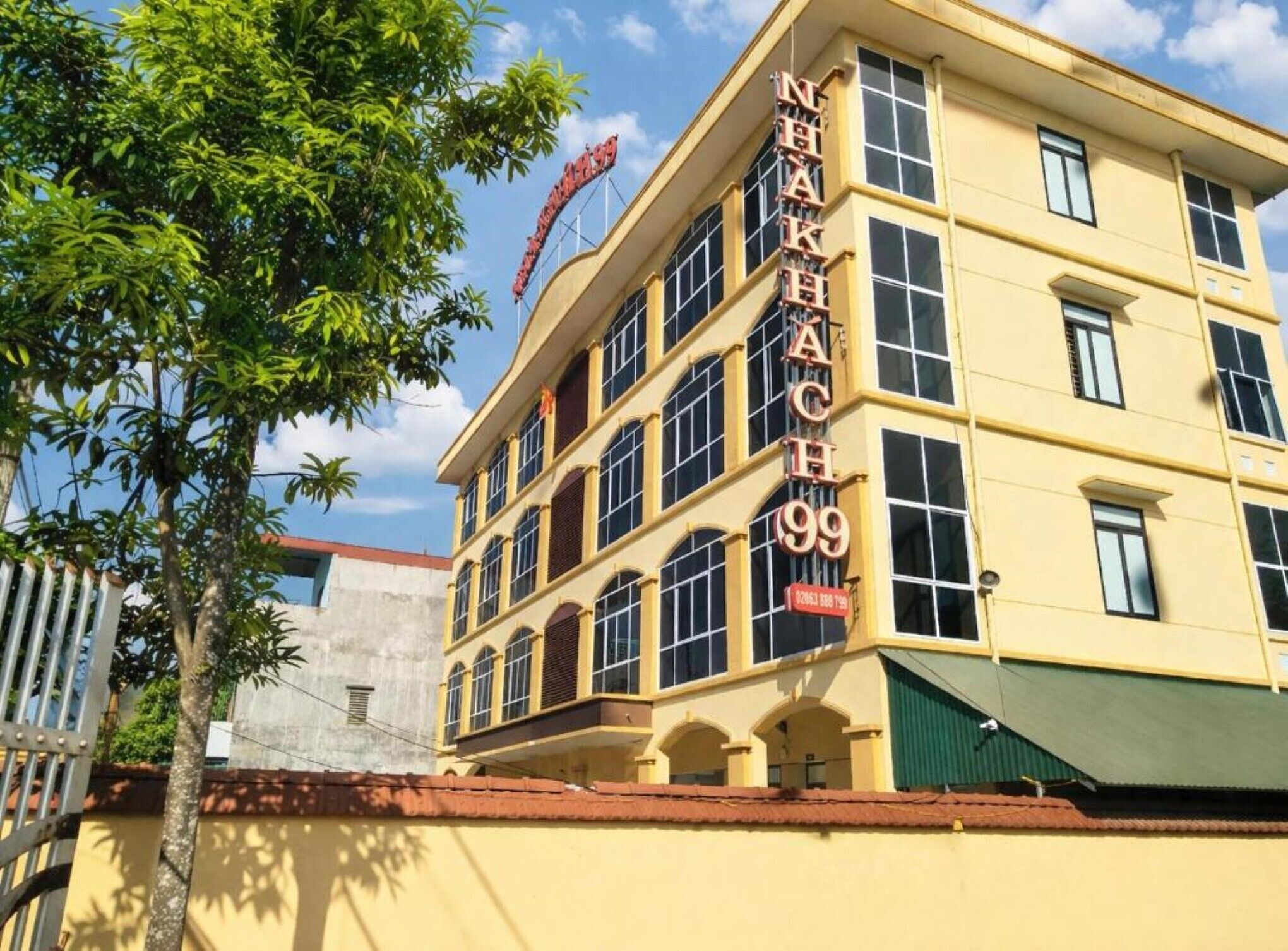 A multi-story building with a sign reading 'NHAK 99' and a partially visible sign above it.