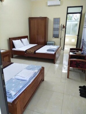 A room with two wooden beds, a wardrobe, a desk with a chair, and a window with blinds. - Hotel 99 (Cao Bang)