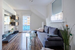Un soggiorno moderno con divano, tavolino e vista esterna.