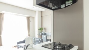 Una cocina moderna con estufa a gas, pileta integrada y extractor de aire negro.