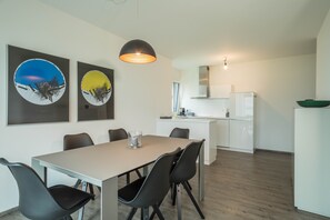 A modern kitchen with white cabinets, a built-in oven, and a green bowl on the counter. - Holiday Apartment "Montfort" Directly on Lake Constance with Views of the Lake and Mountains (Langenargen)