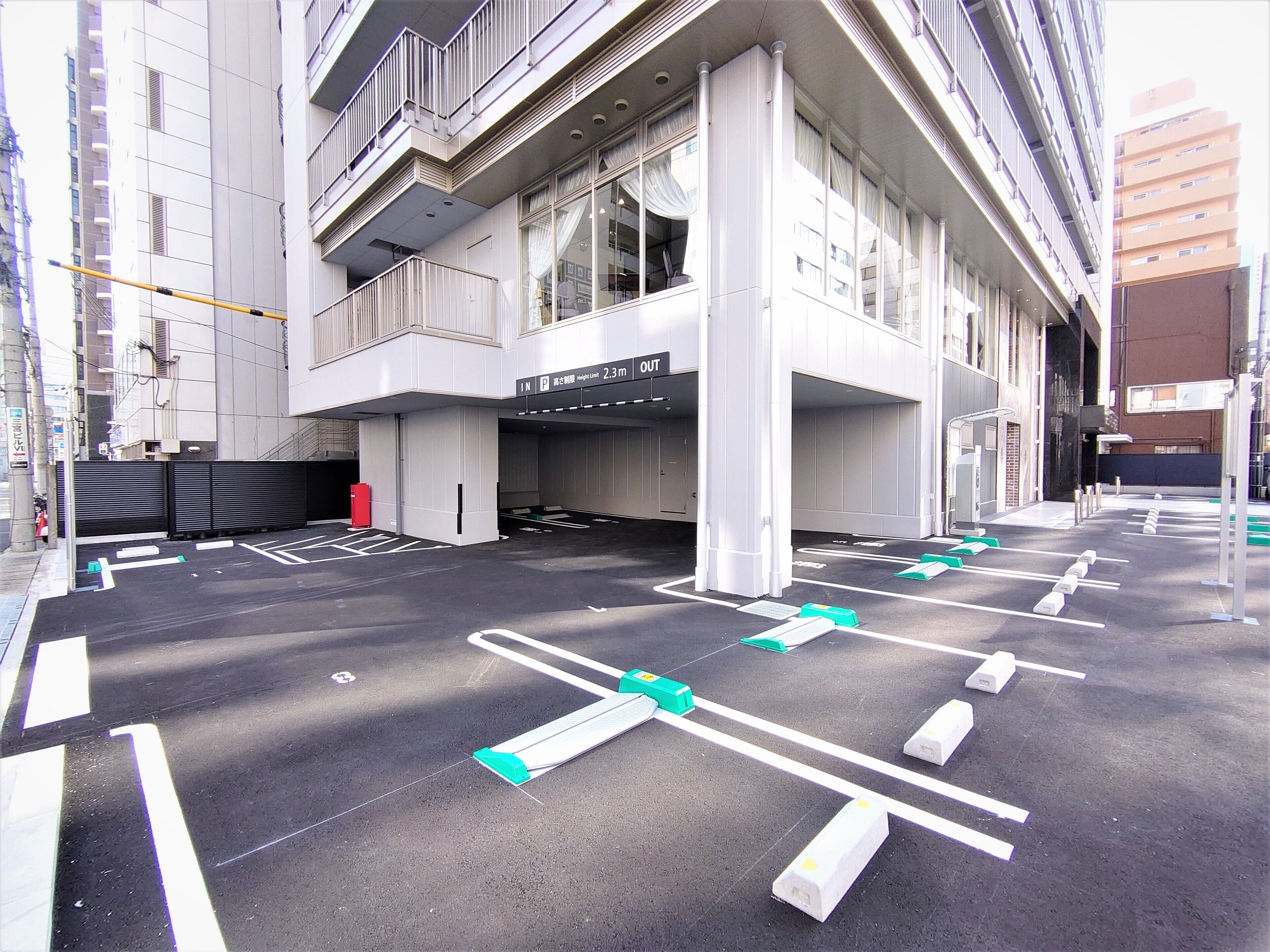 Un estacionamiento de varios niveles y un edificio con ventanas amplias y balcones.