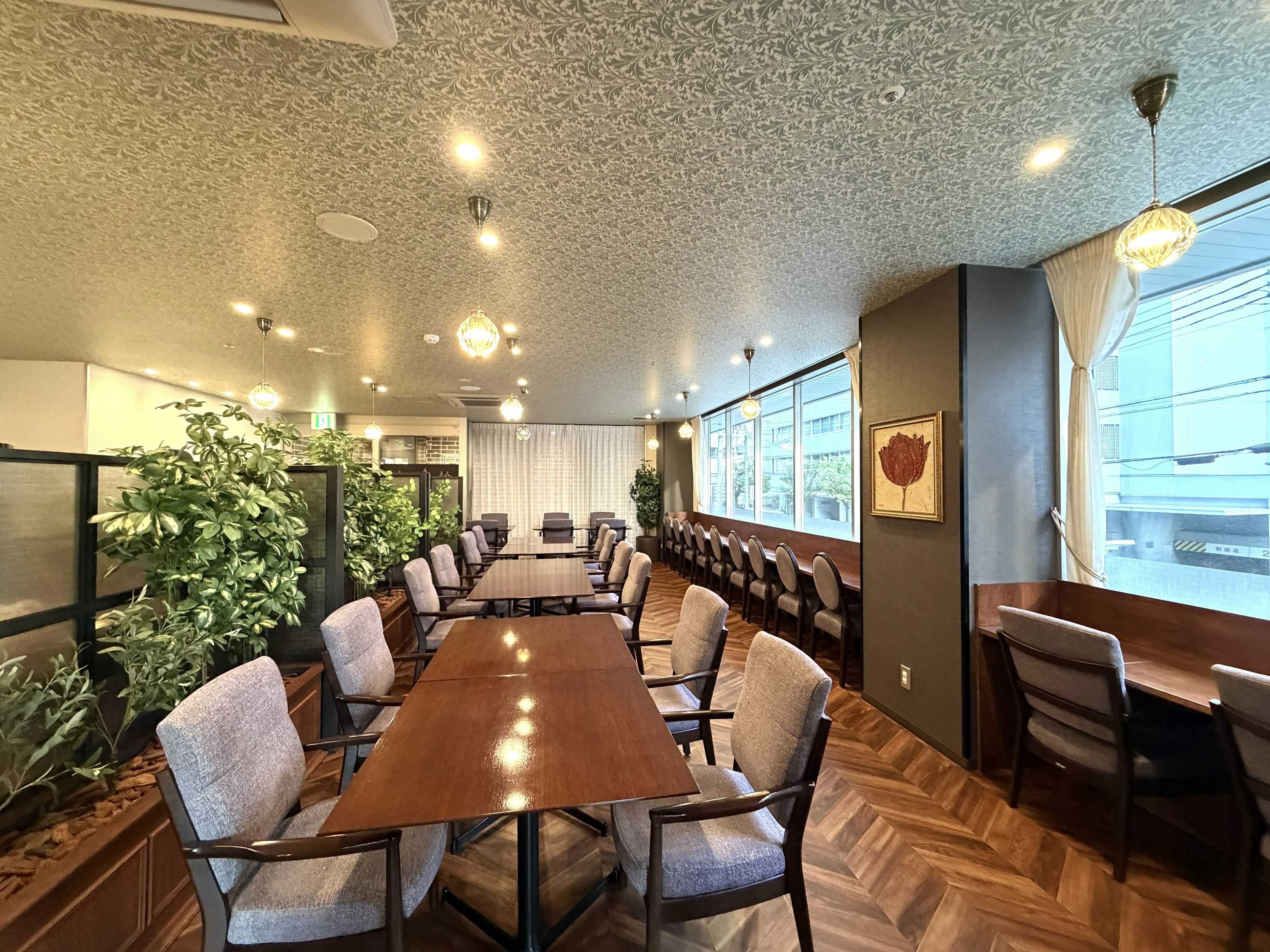 Een vergaderzaal met een lange tafel, stoelen en potplanten.