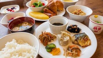 A variety of dishes including rice, fish, and vegetables on a wooden table.