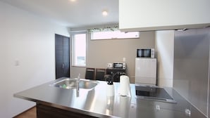 A modern kitchen with stainless steel appliances, a built-in oven, and a microwave. - Sakura34 (Sapporo)