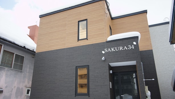A building with a sign reading "SAKURA34" and a modern architectural design. - Sakura34 (Sapporo)