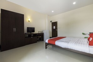 Ein Schlafzimmer mit Bett, Schreibtisch, Stuhl, Kleiderschrank und Fernseher.