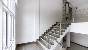 A staircase with metal railings and a tiled floor.