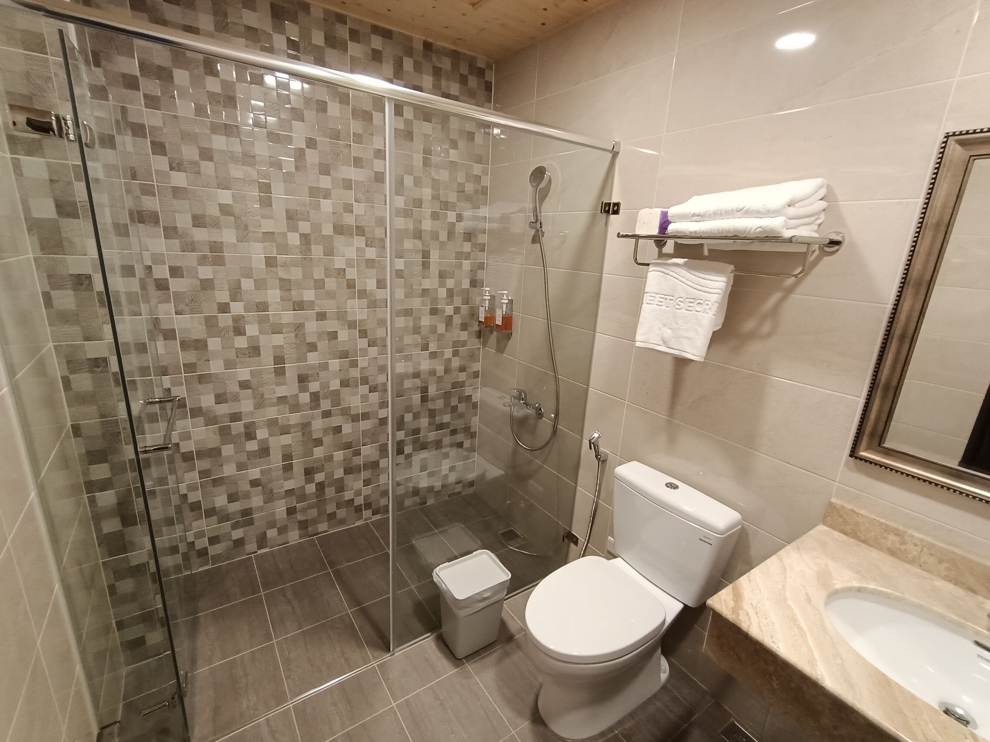 Un baño con ducha de vidrio, inodoro y lavamanos.