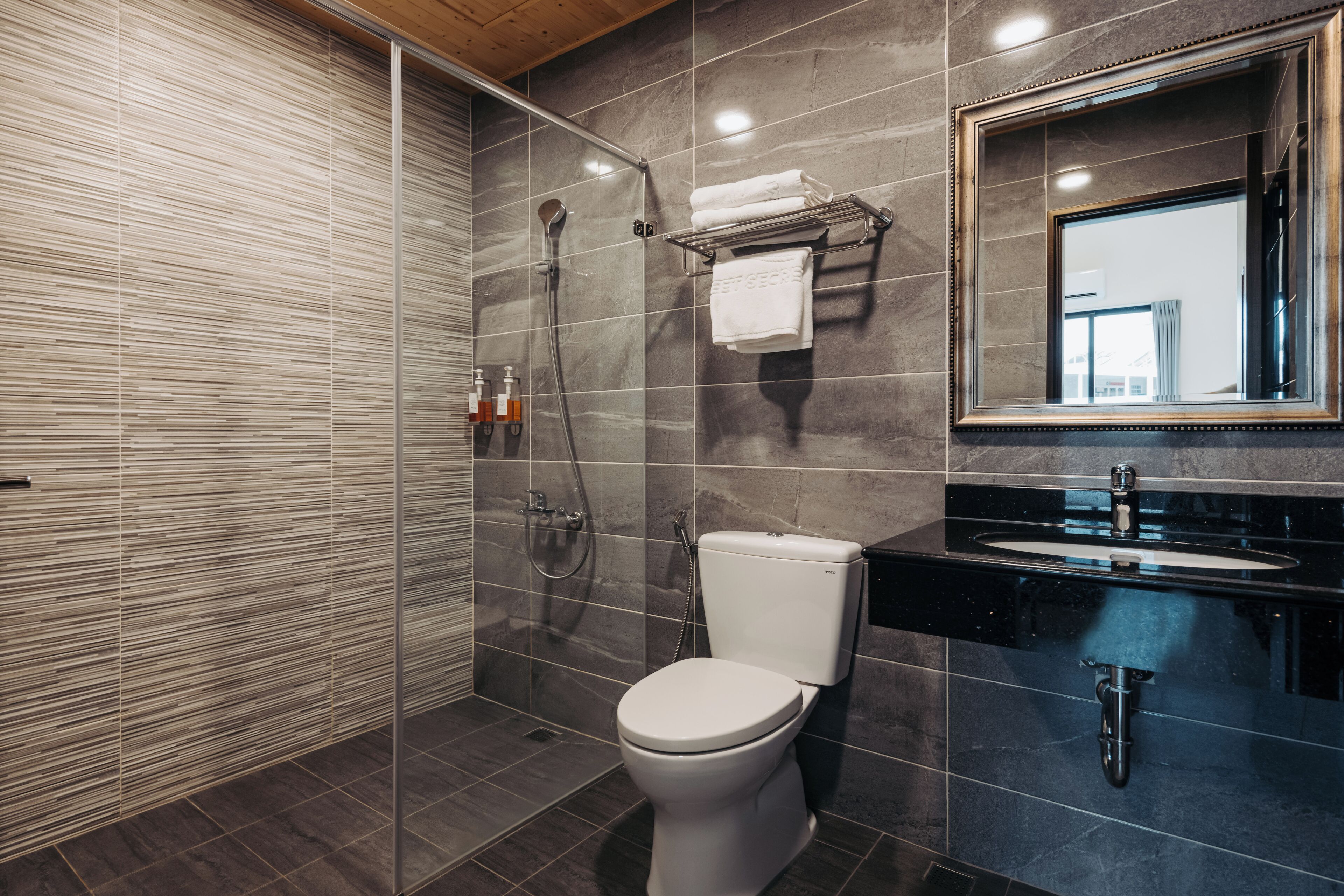 Une salle de bain moderne équipée d’une douche, de toilettes et d’un lavabo.
