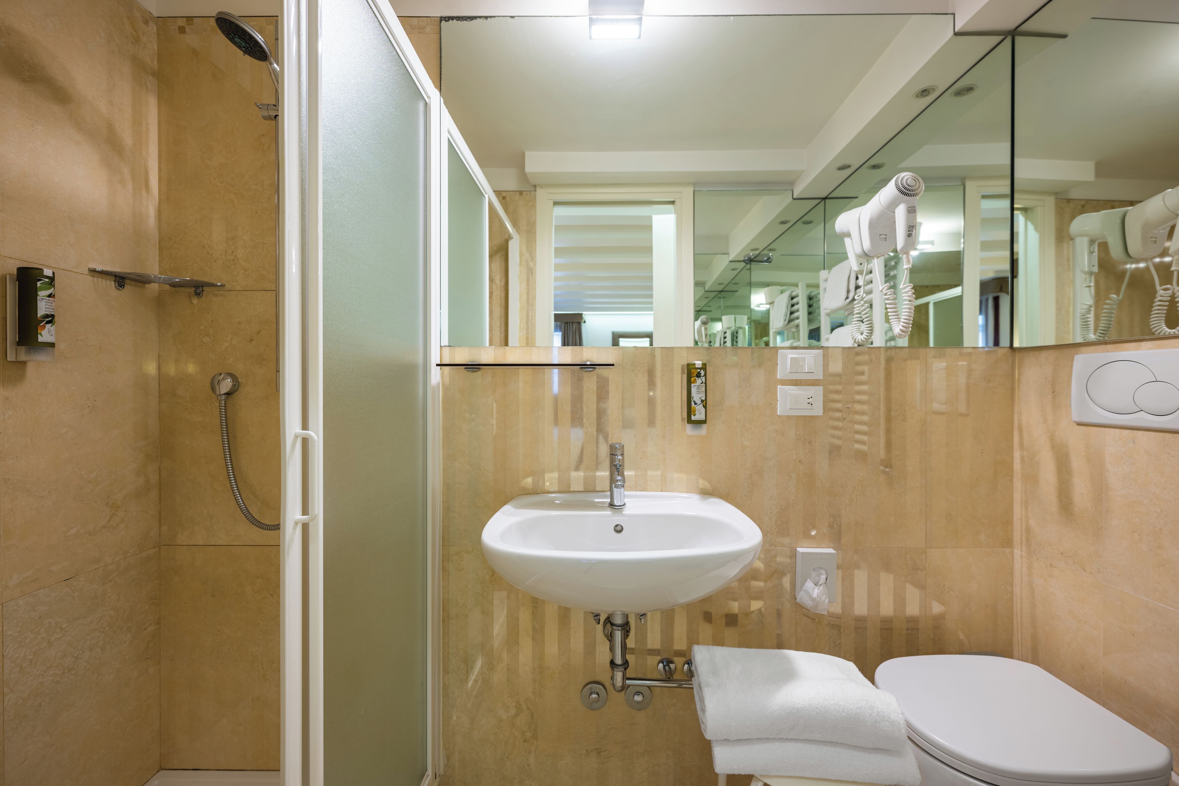 A bathroom with a sink, toilet, and shower.