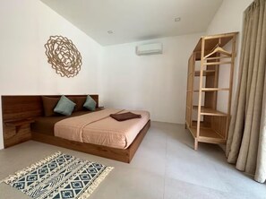 Une chambre à coucher comprenant un lit, un banc en bois, un tapis à motifs, un élément de décoration murale et une armoire en bois.
