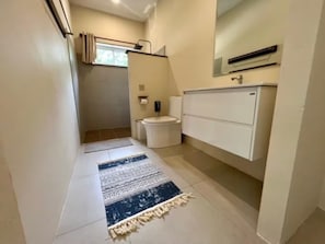 Een badkamer met toilet, wastafel en douchehoek.