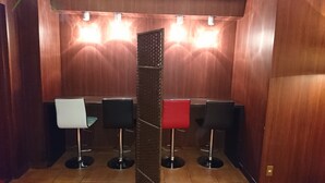 En elevator med træpaneler og tre barstole, hver med et forskelligt farvet sæde.