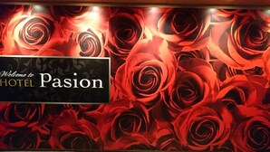 En væg med et blomstermønster og et skilt, der siger "Welcome to HOTEL Passion".