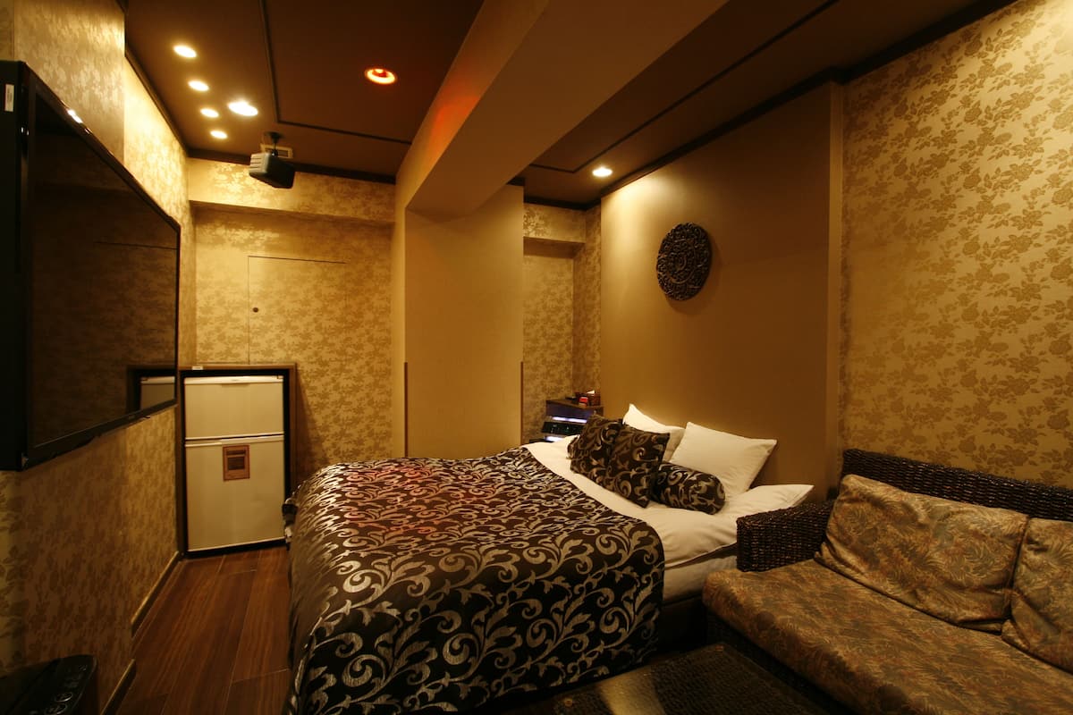 Ein Hotelzimmer mit Bett, einer Couch, einem kleinen Tisch und einem Spiegel.