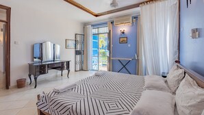 Una camera da letto con un letto grande, una cassettiera, uno specchio e vista sull'esterno.