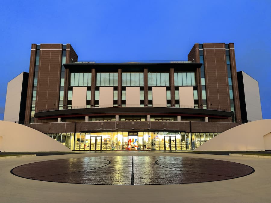 Un bâtiment moderne doté d’une grande entrée et d’un atrium central.