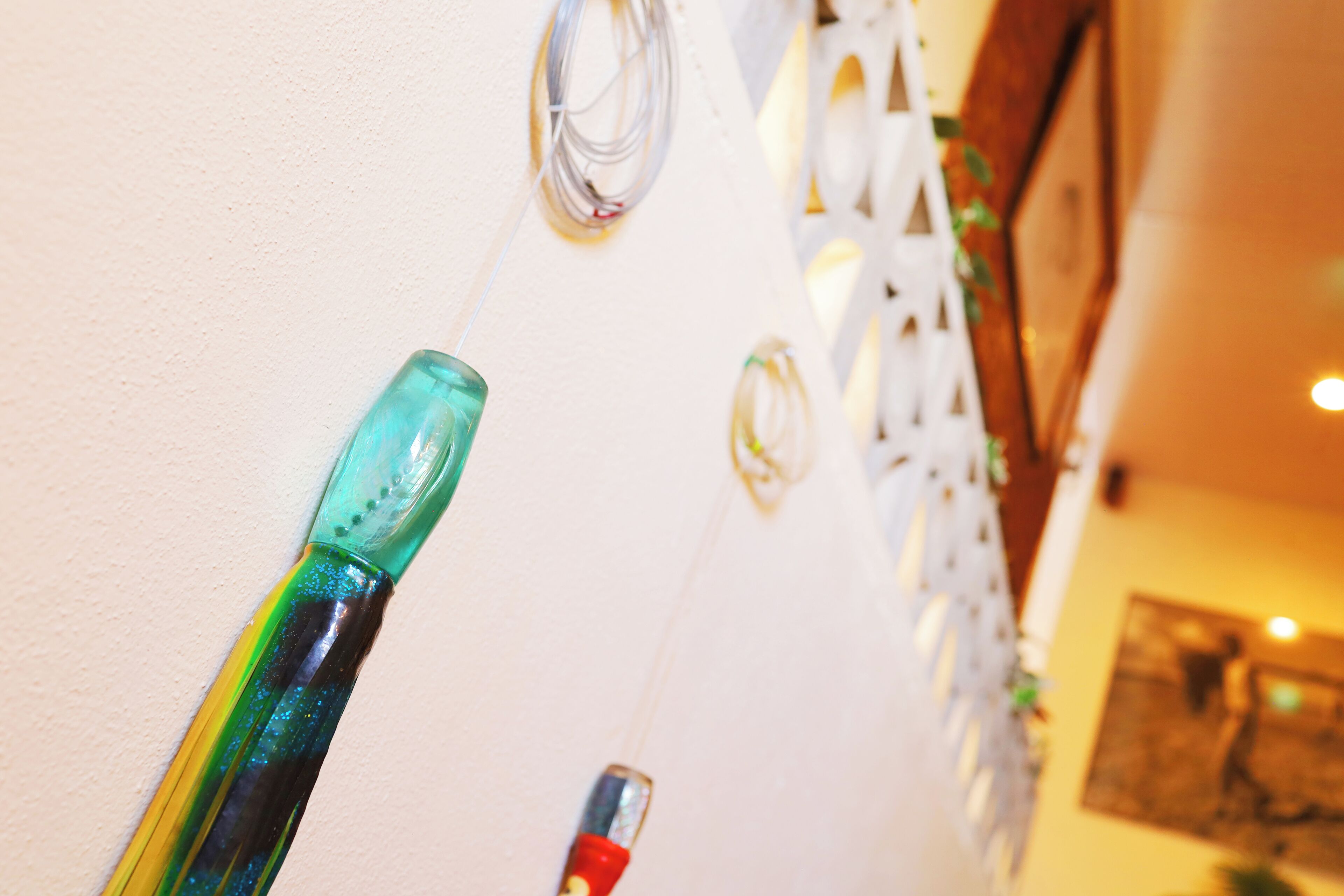 A wall with various decorative items, including a green glass bottle and a red and black object.