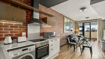 Apartamento exclusivo | Cocina privada | Hervidor eléctrico, utensilios de cocina y mesa de comedor