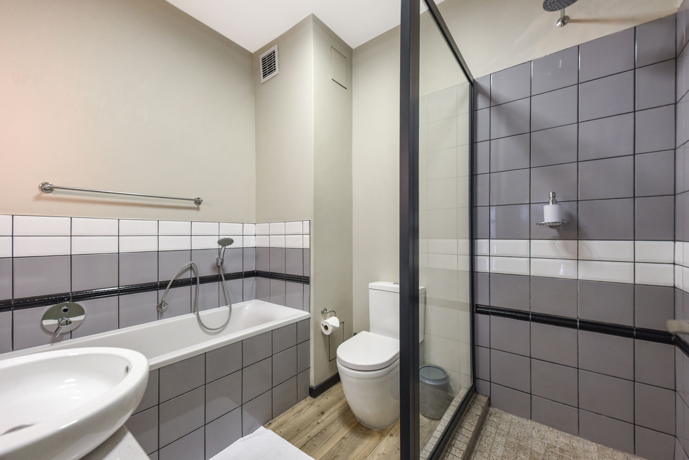 Un baño con bañera, inodoro y zona de ducha.