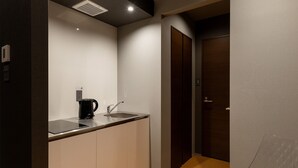 A small kitchenette with a coffee maker, a sink, and a cabinet. - COCOSHUKU Shinjuku-Hanazono (Tokyo)