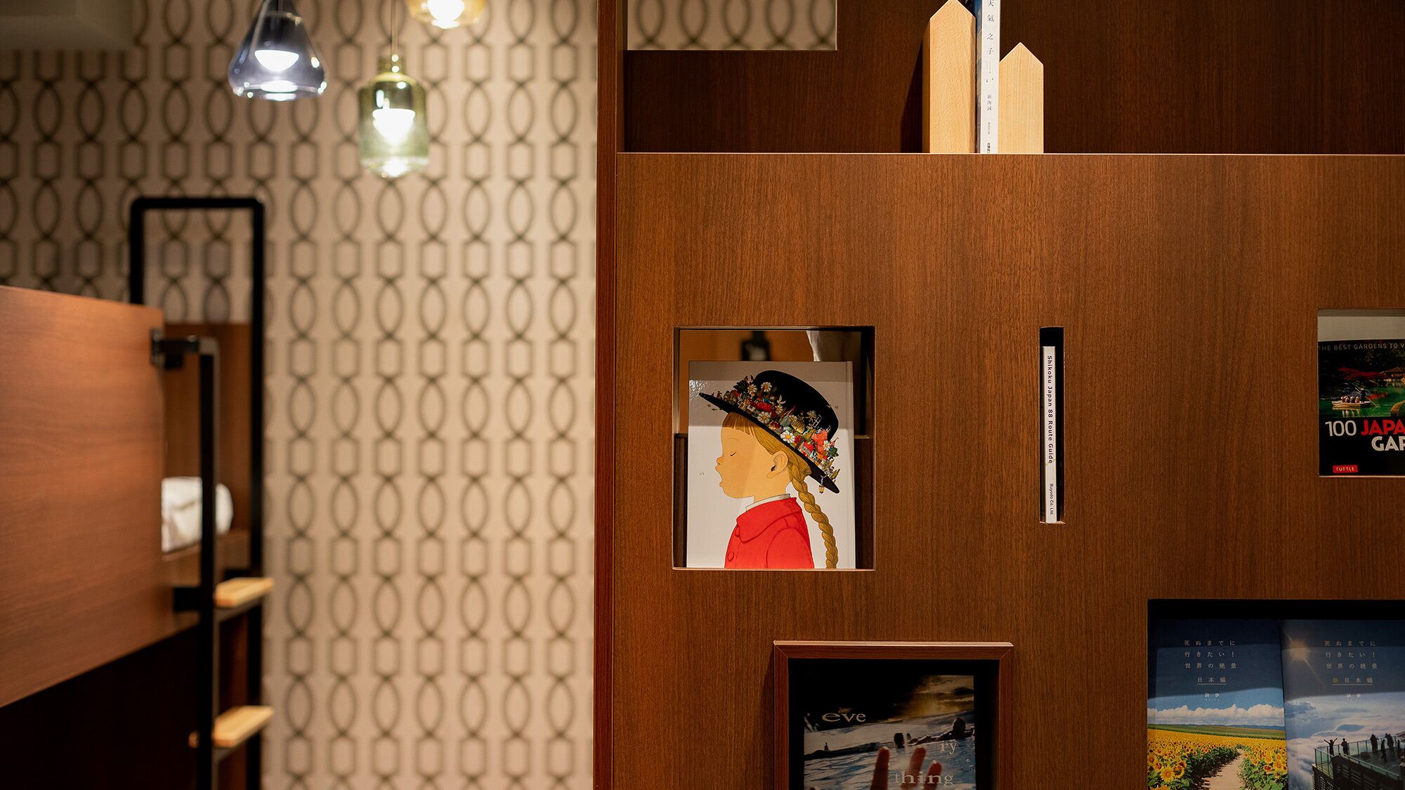 A wooden wall with framed artwork, a guidebook, and a shelf with decorative items.